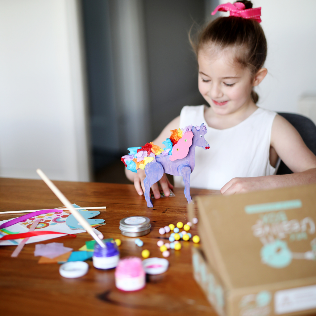 Girl playing with unicorn activity box