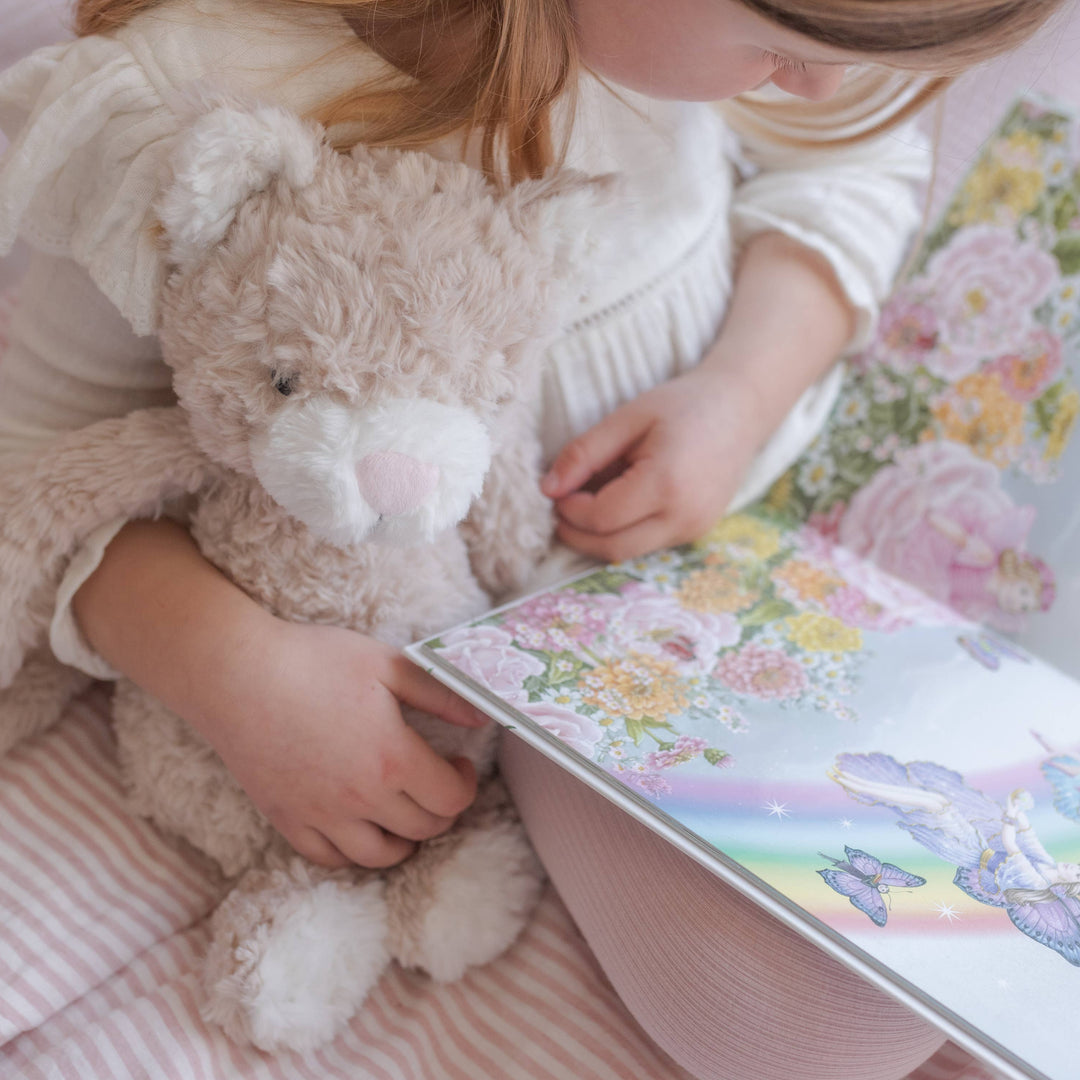 Child reading book to plush toy