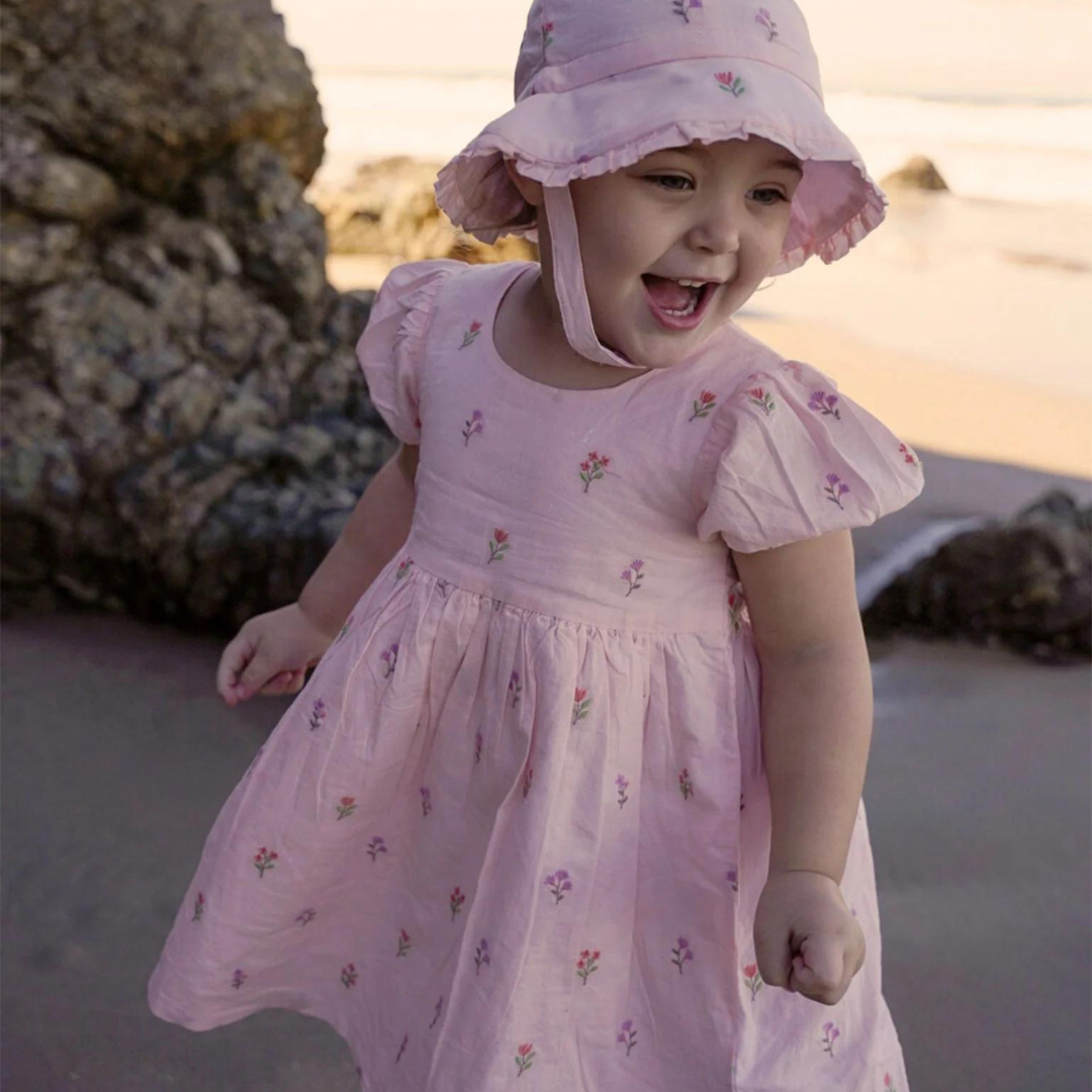 Pure Baby - Little girl at the beach with pretty pink dress