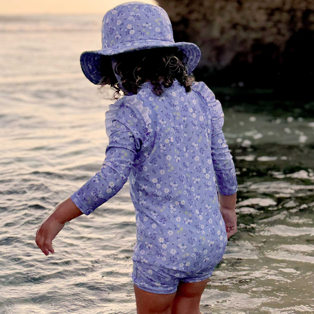 Pure Baby - Girl at the beach with long sleeve purple rashie