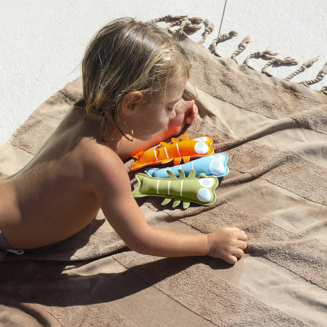 Boy playing with Sunnylife Dive Buddies on Towel