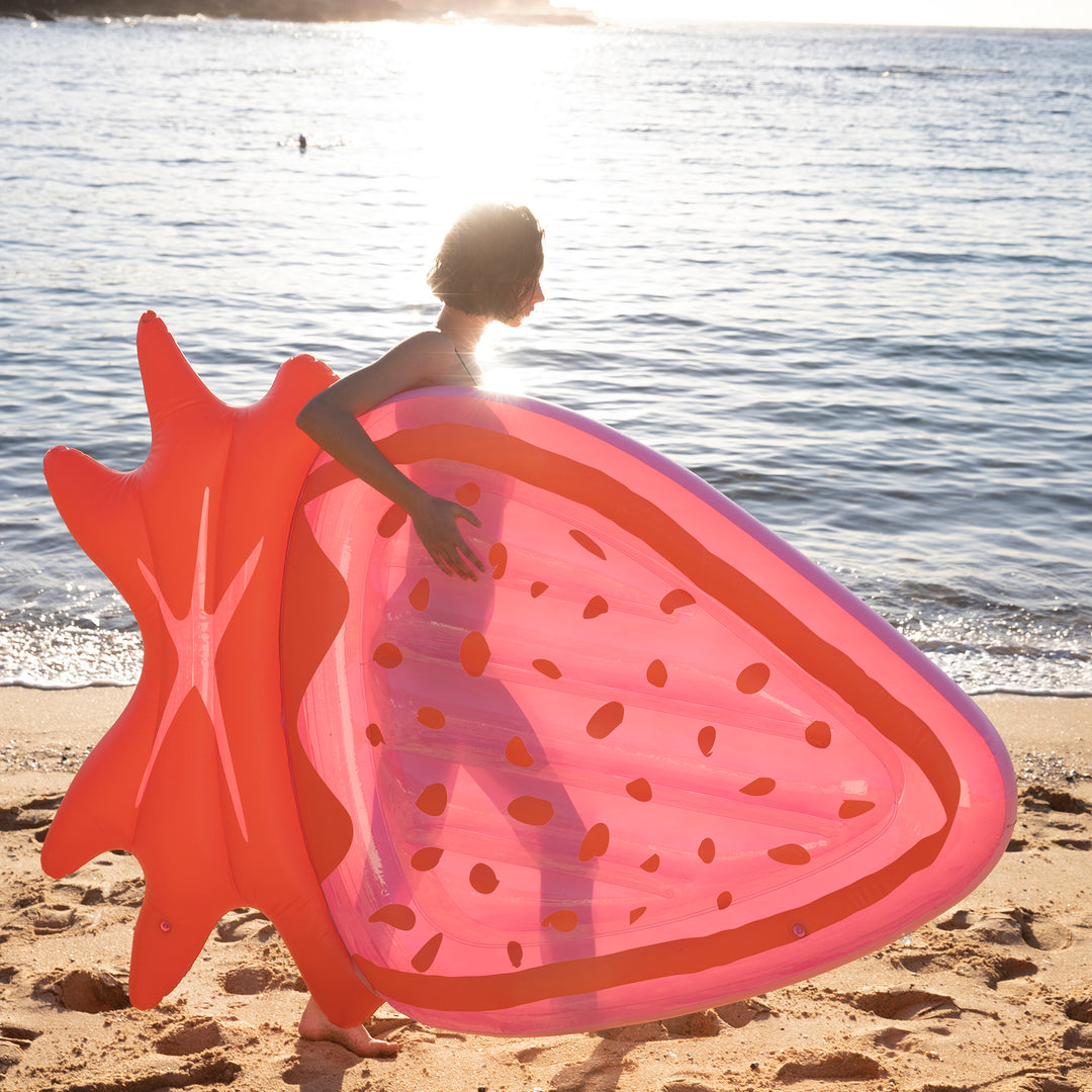 Sunnylife - Woman at the beach with strawberry floatie